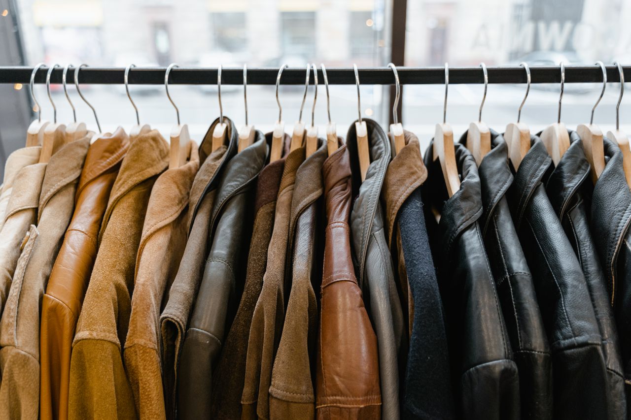 about-img A collection of leather and suede jackets hanging on a clothes rack in a stylish boutique.